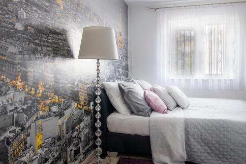 - une chambre avec un lit et une lampe à côté dans l'établissement Apartman Ante, à Vinkovci