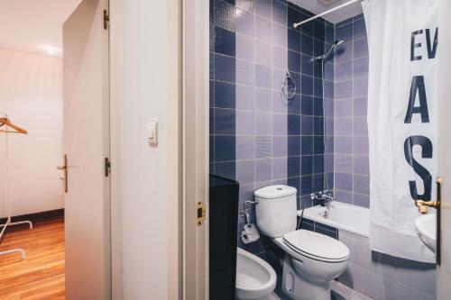 a blue tiled bathroom with a toilet and a sink at Old Town Madari by People Rentals in Bilbao