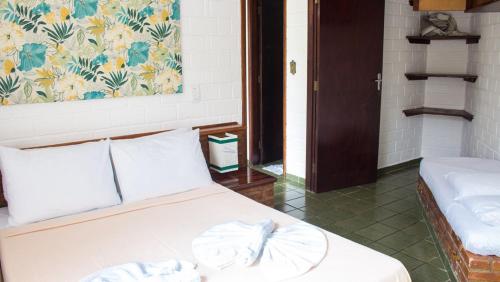 a bedroom with a bed with two towels on it at Pousada Albatroz in Ubatuba