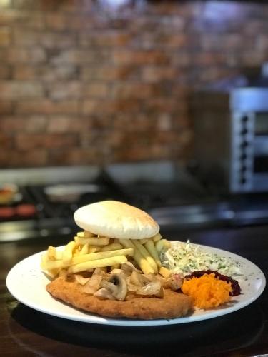 a sandwich with french fries and cheese on a plate at Hotel Kaliski in Słubice
