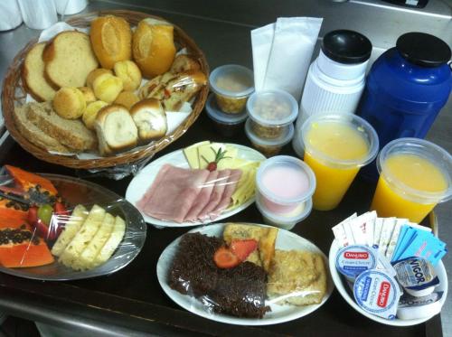 a table with plates of breakfast foods and glasses of orange juice at Morada do Guaruçá in Bombinhas