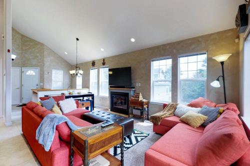 a living room with two red couches and a fireplace at Beach house with a park in Lincoln City