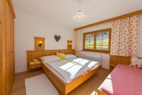 a bedroom with a bed and a window at Oberdeutinghof in Saalfelden am Steinernen Meer