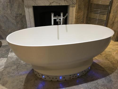 a large white bath tub in a bathroom at The Ship Leopard Hotel - No Children in Portsmouth