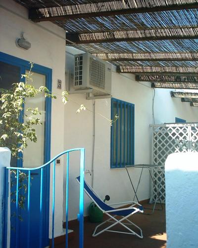 a house with a blue chair and a fan at Case Vacanze Levante in Vulcano