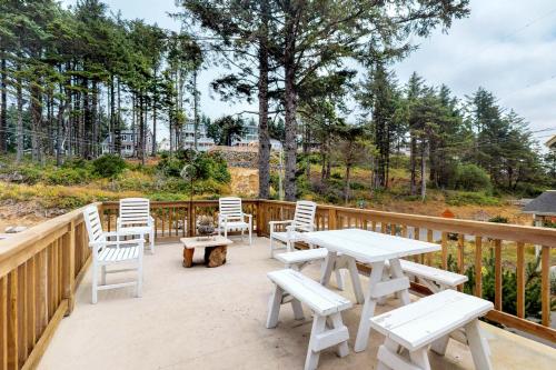 a patio with white tables and chairs on a wooden deck at Beach house with a park in Lincoln City