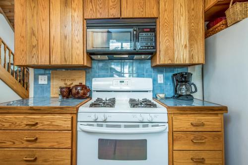 a kitchen with a white stove and a microwave at Sparrow Cove in Shaver Lake