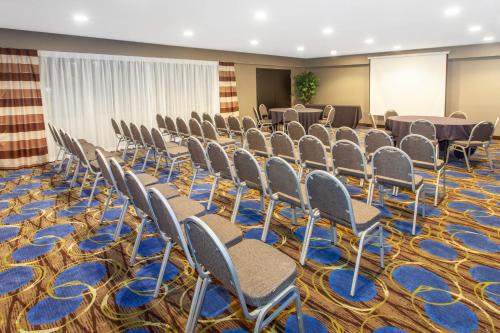 a room with rows of chairs and a screen at Wyndham Garden Fort Wayne in Fort Wayne
