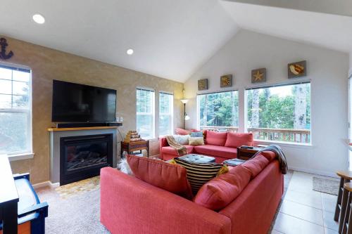 a living room with a red couch and a fireplace at Beach house with a park in Lincoln City
