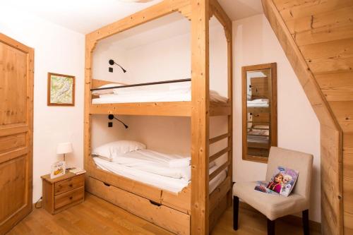 Habitación con litera, silla y espejo. en Le Paradis 18 & 18b appts - Chamonix All Year en Chamonix-Mont-Blanc