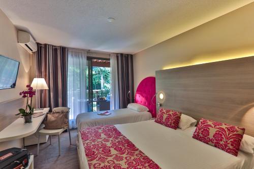 une chambre d'hôtel avec deux lits et un bureau dans l'établissement Servotel Castagniers, à Castagniers