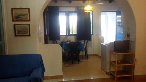 a living room with a table and a room with a couch at Case Vacanze Levante in Vulcano