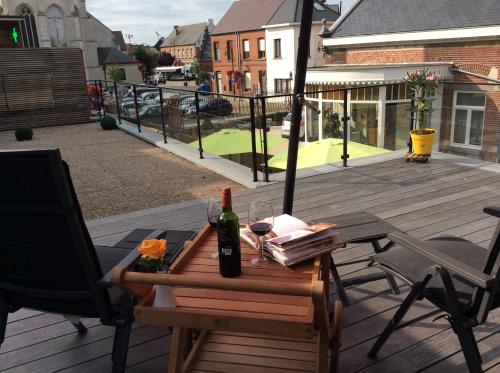 a bottle of wine sitting on a table on a deck at Biotina in Lebbeke