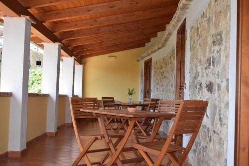 a dining room with a wooden table and chairs at Country House B&B Antica Dimora Del Sole in Camerota