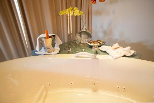 a bathroom with a bath tub and a sink at Speicher Barth - Superior-Hotel in Barth