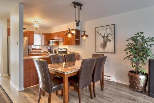 a kitchen and dining room with a wooden table and chairs at Mont-Tremblant in Mont-Tremblant