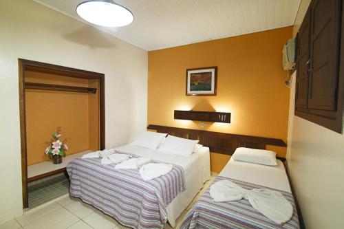 a room with two beds in a hotel room at Hotel Mato Grosso Águas Quentes in Sucuri