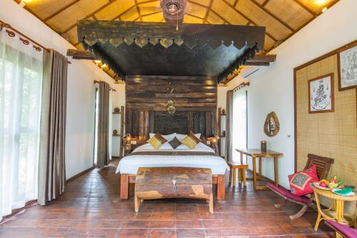 a bedroom with a bed with a wooden ceiling at Bong Thom Forest Lodge in Siem Reap
