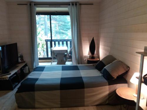 una camera con un letto in una stanza con una finestra di Les Genets a Valdeblore