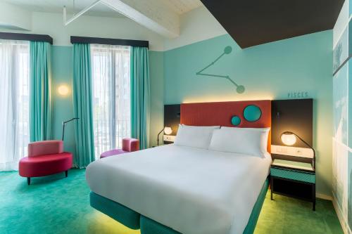 a hotel room with a large bed and a chair at Room Mate Bruno, Rotterdam in Rotterdam