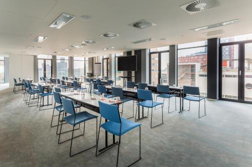 a conference room with tables and blue chairs at Room Mate Bruno, Rotterdam in Rotterdam