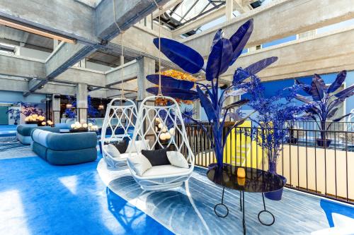 a lobby with white chairs and potted plants at Room Mate Bruno, Rotterdam in Rotterdam