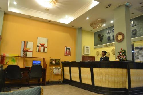 a woman sitting at a bar in a waiting room at Hotel Nikko Towers in Dar es Salaam