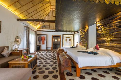 Bong Thom Forest Lodge في سيام ريب: غرفة فندقية بثلاث اسرة واريكة