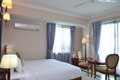 a hotel room with a bed and a table and chairs at Hotel Nikko Towers in Dar es Salaam