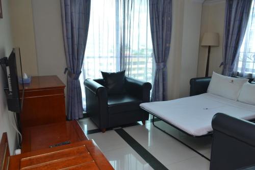 a living room with a bed and a couch and a chair at Hotel Nikko Towers in Dar es Salaam