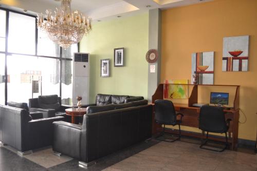 a waiting room with couches and a table and a chandelier at Hotel Nikko Towers in Dar es Salaam