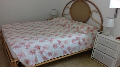 a bedroom with a bed with a white and pink bedspread at Casa Mare Ognina in Ognina