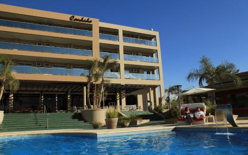 a hotel with a swimming pool in front of a building at Condado Hotel Casino Paso de la Patria in Paso de la Patria