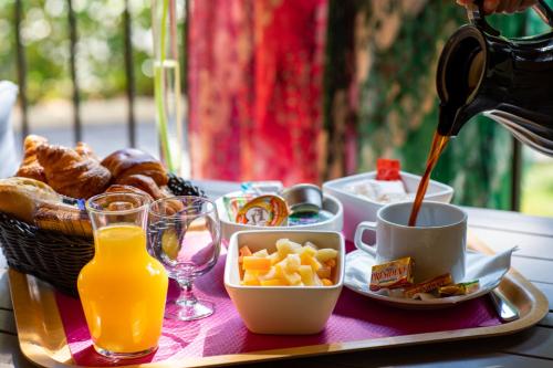 een ontbijtpakket met een mand met eten en sinaasappelsap bij Servotel Castagniers in Castagniers