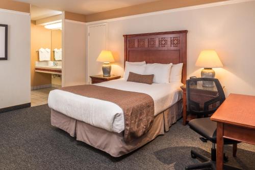 a hotel room with a large bed and a desk at Laurel Inn & Conference Center in Salinas