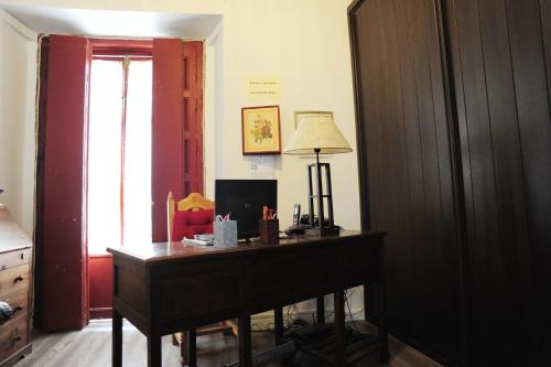 a room with a desk with a lamp and a window at Hospederia Marqués in Cádiz