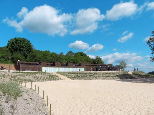 a sandy beach with a building in the background at Ferienhaus Nr. 52 im Ferienpark am Twistesee in Bad Arolsen