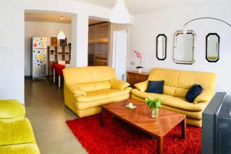 una sala de estar con 2 sofás amarillos y una mesa. en La Casa de Antón, en Tineo