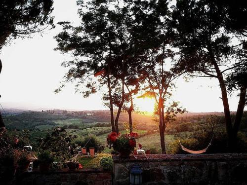a view of the sun setting over a field with trees at Mancino in Poggibonsi