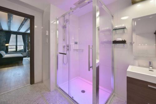 a bathroom with a glass shower and a sink at Hotel Épik Montréal in Montréal