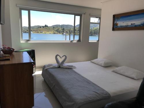 a bedroom with a bed with a heart decoration on it at Hotel Bahia Guatape in Guatapé