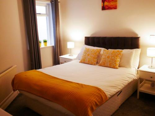 a bedroom with a large bed with an orange blanket at Townhouse Tullamore in Tullamore