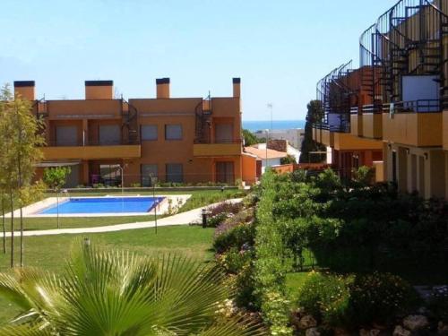 an apartment building with a swimming pool in front of it at Masia Blanca - Coma-ruga in Comarruga