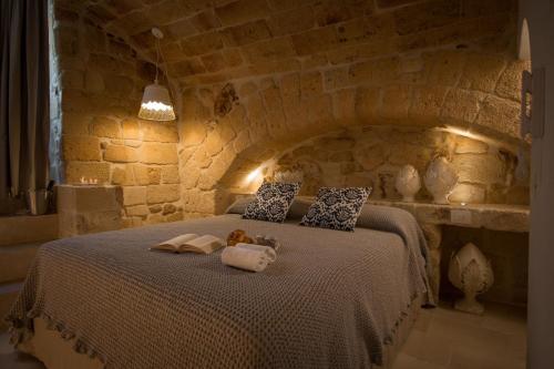 - une chambre avec un grand lit dans un mur en pierre dans l'établissement Casa Regina Paola, à Monopoli