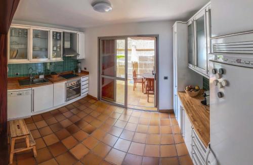 una cucina con armadietti bianchi e pavimento piastrellato di Casa Paradise a El Médano