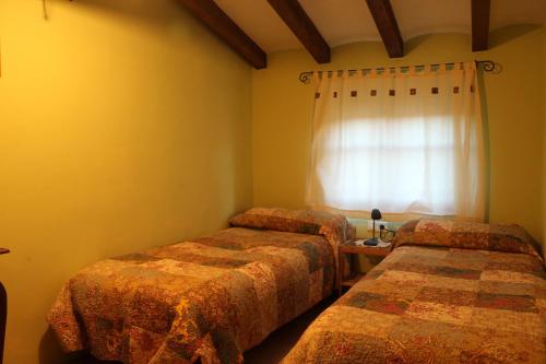 2 camas en una habitación con ventana en Ca la Nuri, en Senant