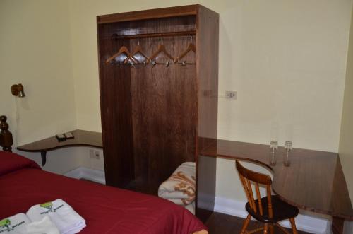 a bedroom with a bed and a wooden cabinet at Hotel Romi in Colonia del Sacramento