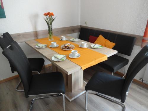 a table with chairs and a vase of flowers on it at Haus Kinsperger in Klösterle am Arlberg