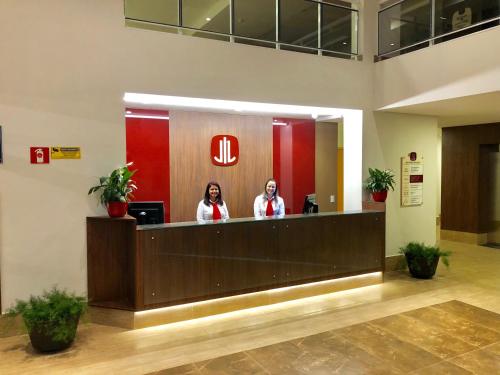 two people standing at a reception desk in a lobby at Lummina Mogi in Mogi-Guaçu