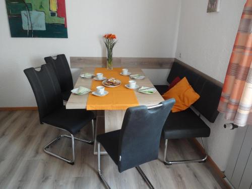 a dining room table with chairs and a orange table cloth at Haus Kinsperger in Klösterle am Arlberg